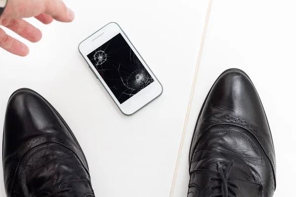 Podnikatel vyvolává jeho rozbité smartphone od podlahy — Stock fotografie