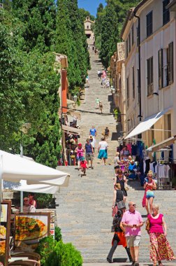 Mallorca, Balearic Islands, Spain, June 6, 2012: people coming down and climbing the 365 Calvary steps (Bottom Of Steps) in Pollenca, the big staircase of 365 steps leading to the little Church of Virgen de los Angeles clipart