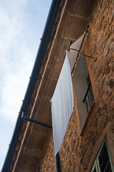 Mallorca, Balearic Islands, Spain: a white curtain on a window in an alley of the old village of Fornalutx — Stock Photo, Image