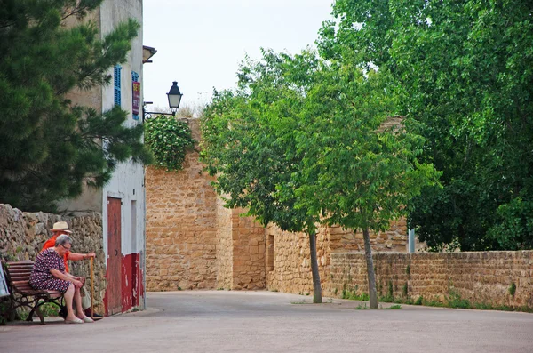 Mallorca, Islas Baleares, España: una pareja de ancianos sentados en un banco en el casco antiguo de Alcudia — Foto de Stock