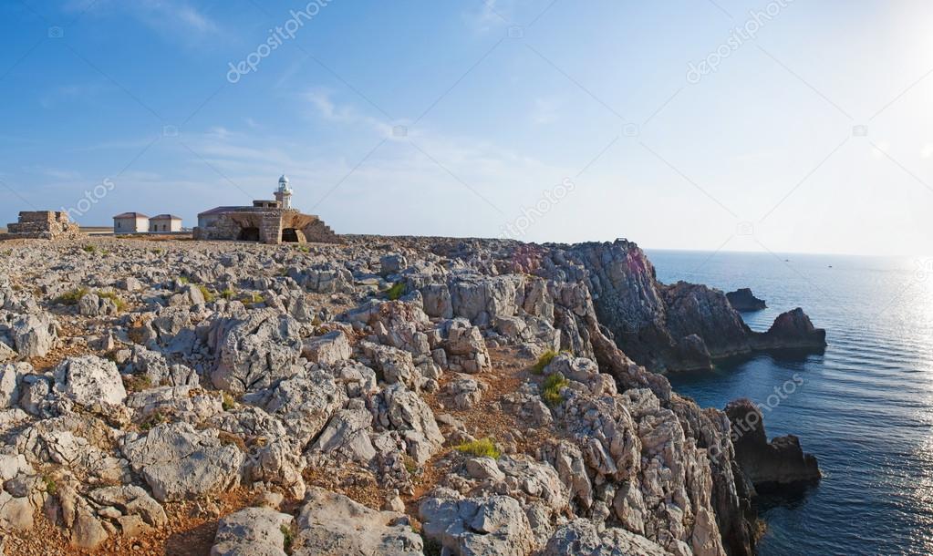 Menorca, Balearic Islands, Spain: the cliff with the Punta Nati lighthouse, octagonal tower with balcony and lantern, an active lighthouse built in 1911 in the far northwest of the island
