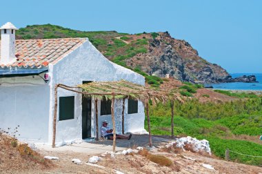 Menorca, Balear Adaları, İspanya: Cala Mesquida beach yakınındaki bir gölgelik altında uyuyan bir adam 