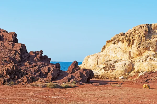 Menorca, Islas Baleares, España: arena roja y rocas en el camino hacia la playa de Cala Pregonda — Foto de Stock