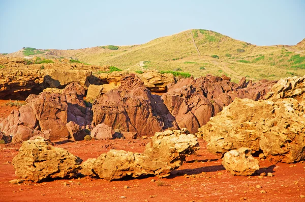 Менендес, Балеарские острова, Испания: красный песок и скалы на пути к пляжу Кала-Прегонда — стоковое фото