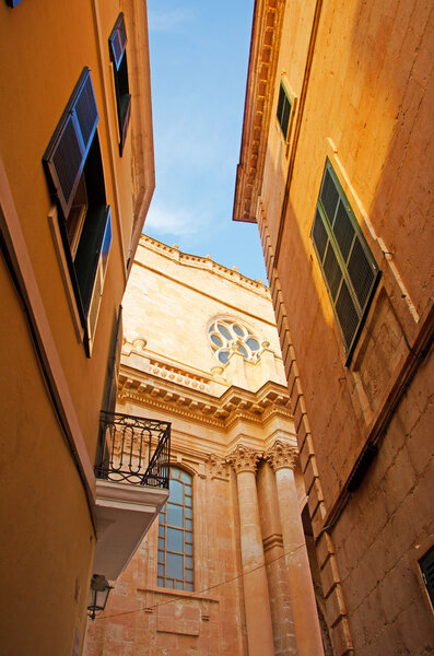 Menorca, Balearic Islands, Spain, July 7, 2013: the alleys and the Cathedral Basilica of Ciutadella, the Church of Saint Mary constructed in 1287 on the site of an old mosque, seen through the buildings of the old town