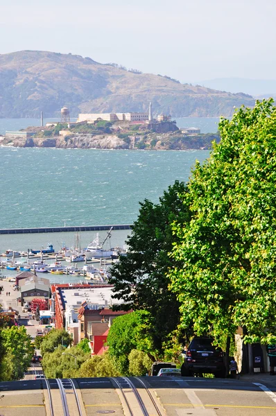 San Francisco: kabelbaan rails in Hyde straat met Alcatraz island op de achtergrond — Stockfoto