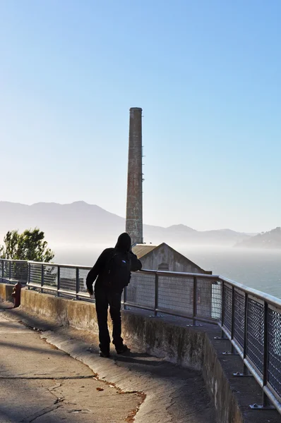 Alcatraz island, kalifornien: ein mann vor dem kraftwerk, das 1939 auf dem ehemaligen bundesgefängnis errichtet wurde, als teil eines modernisierungsprogramms, das auch den wasserturm und die offiziersquartiere umfasste — Stockfoto