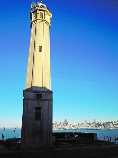 Острів Алькатрас, Каліфорнія: Алькатрас острів маяка, перша побудована на західному узбережжі, розташований на південному кінці колишнього федеральної в'язниці, skyline Сан-Франциско на тлі — стокове фото
