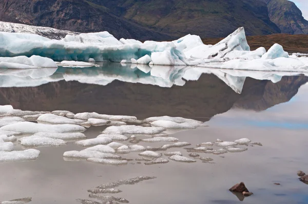 Islândia: icebergs flutuantes na lagoa glaciar Fjallsarlon, um lago glacial no Parque Nacional Vatnajokull — Fotografia de Stock