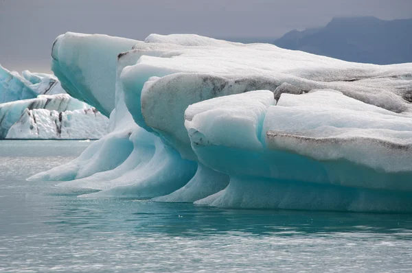 Islandia, Europa: icebergs flotantes en la laguna glaciar Jokulsarlon, un gran lago glaciar en el sureste de Islandia, en el borde del Parque Nacional Vatnajokull se desarrolló después de que el glaciar retrocediera desde el borde del Océano Atlántico — Foto de Stock