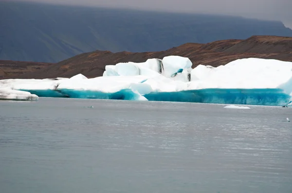 アイスランド、ヨーロッパ:氷河が大西洋の端から後退した後に開発されたヴァトナジョクル国立公園の端に、アイスランド南東部の大きな氷河湖、ヨクルサルロン氷河ラグーンに浮かぶ氷山 — ストック写真