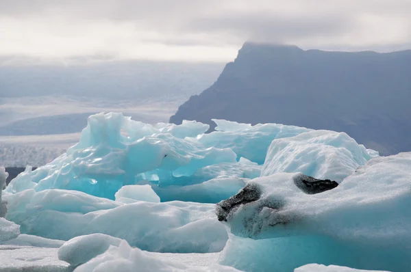 Island, Europa: Schwimmende Eisberge in der Jokulsarlon-Gletscherlagune, einem großen Gletschersee im Südosten Islands, am Rande des Vatnajokull-Nationalparks, der entstanden ist, nachdem der Gletscher vom Rand des Atlantischen Ozeans zurückgegangen ist — Stockfoto