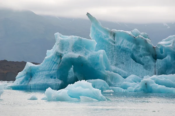 IJsland, Europa: drijvende ijsbergen in de Jokulsarlon gletsjerlagune, een groot gletsjermeer in Zuidoost-IJsland, aan de rand van het Vatnajokull National Park, ontwikkeld nadat de gletsjer is teruggetrokken van de rand van de Atlantische Oceaan — Stockfoto