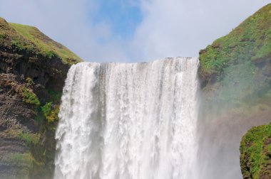 İzlanda, Avrupa: Skogafoss şelalesi görünümü, Skoga Nehri üzerinde bulunan ünlü turistik, eski kıyı şeridinin kayalıklarında, adanın güneyinde, genişliği 25 metre ve 60 metre lik bir damla ile