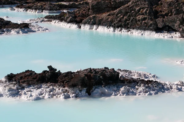 Iceland, Europe: silica water and black rocks at the Blue Lagoon, a famous geothermal spa in a lava field in Grindavik, Reykjanes Peninsula, one of the most visited attractions in Iceland — Stock Photo, Image