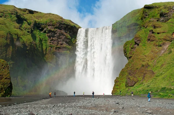 Iceland, Europe: a rainbow and view of Skogafoss waterfall, famous tourist attraction situated on the Skoga River, at the cliffs of the former coastline, in the south of the island, with a width of 25 metres and a drop of 60 metres — 图库照片