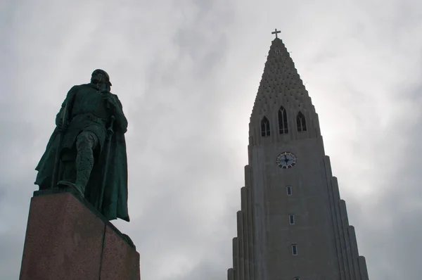 Reykjavik, Islandia, Europa: vista retroiluminada de la estatua del explorador Leif Eriksson (970-1020) de Alexander Stirling Calder, donado a la ciudad capital desde los Estados Unidos en 1930, frente a Hallgrimskirkja (iglesia Hallgrimur ) — Foto de Stock