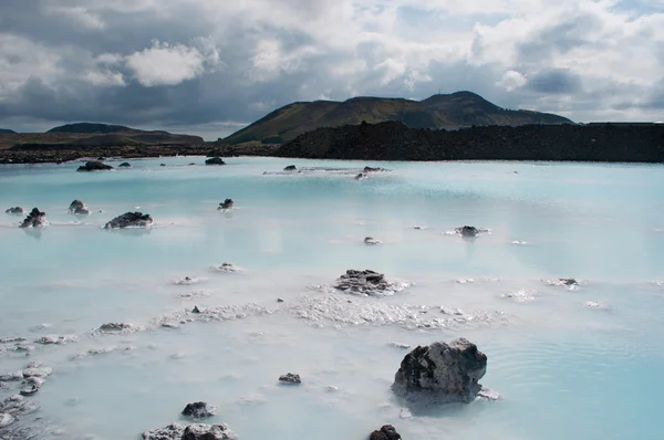 Iceland, Europe: silica water and black rocks at the Blue Lagoon, a famous geothermal spa in a lava field in Grindavik, Reykjanes Peninsula, one of the most visited attractions in Iceland