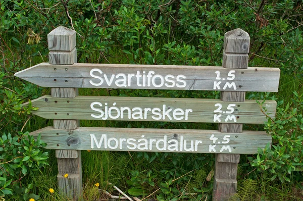 Island, Europa: Holzschild auf dem Fußweg zum svartifoss-Wasserfall, schwarze Wasserfälle, eine berühmte Touristenattraktion in Skaftafell, im Vatnajokull-Nationalpark, umgeben von dunklen Lavasäulen — Stockfoto