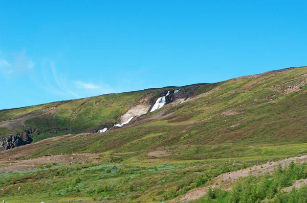 IJsland: uitzicht op het IJslandse landschap met bergen en een waterval — Stockfoto