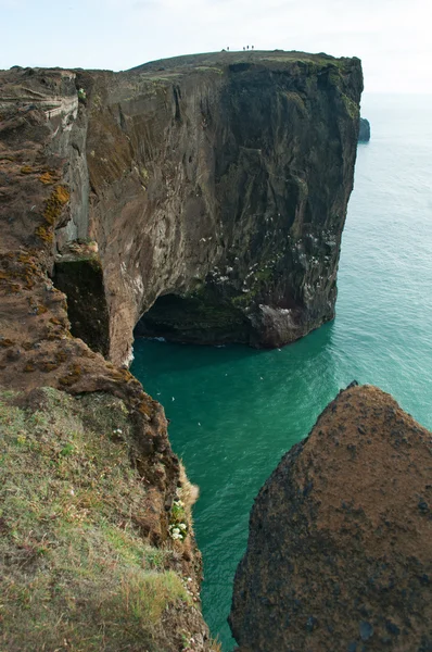 Island, Europa: Luftaufnahme des gigantischen schwarzen Lavabogens, der im Meer auf der Landzunge von Dyrholaey steht und die Bucht von Vik i Myrdal überblickt, dem südlichsten Dorf der Insel, einer der wichtigsten Touristenattraktionen des Südens — Stockfoto