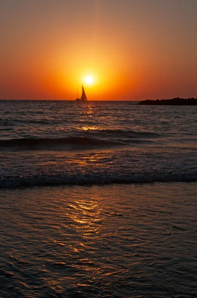 Tel Aviv, Israele: veduta del Mar Mediterraneo e una barca a vela al tramonto sulla spiaggia — Foto Stock