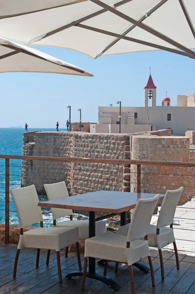 Israel: Acre Sea Walls trough the outdoor umbrellas of a restaurant
