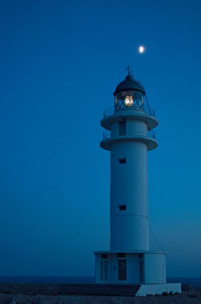 Formentera, Balearic Islands, Spain: the moon and Es Cap de Barbaria Lighthouse, beacon built in 1972 and located at the far southern tip of the island on the top of a rocky cliff — Stock Photo, Image