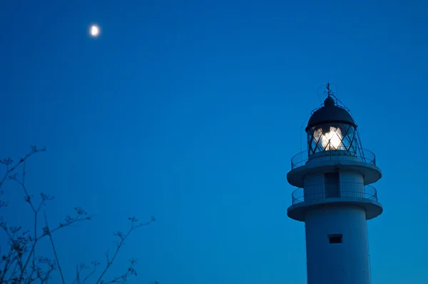 Formentera, Islas Baleares, España: la luna y el faro de Es Cap de Barbaria, faro construido en 1972 y situado en el extremo sur de la isla en la cima de un acantilado rocoso — Foto de Stock