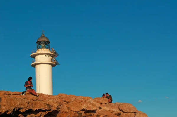 Formentera, Balearic Islands, Spain: people waiting for sunset at Es Cap de Barbaria Lighthouse, beacon built in 1972 and located at the far southern tip of the island on the top of a rocky cliff — Stock Photo, Image