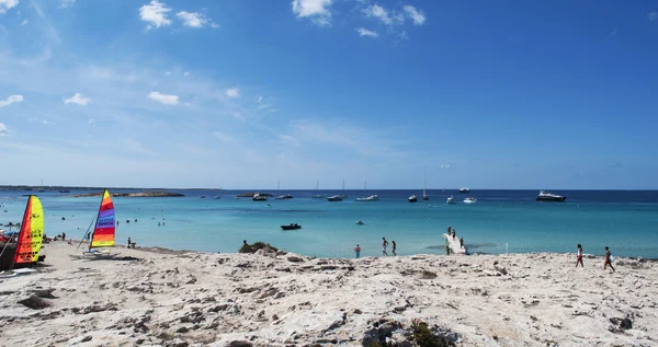 Formentera, Isole Baleari, Spagna: windsurf e vista mozzafiato sulle barche a vela ormeggiate al largo della spiaggia di Ses Illetes, sul lato occidentale della penisola di Trucador, una delle spiagge più famose dell'isola — Foto Stock