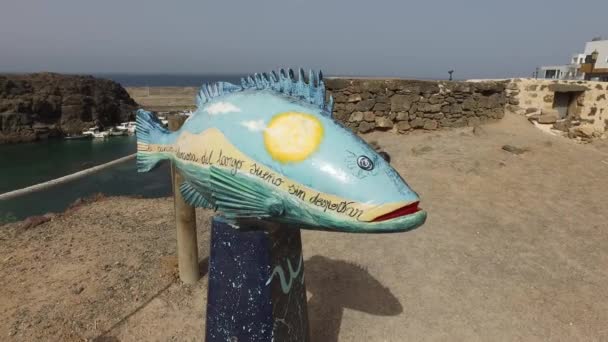 El Cotillo, Fuerteventura, Canary Islands, Spain August 29, 2016: Overview of the coast of the village of El Cotillo with the Castillo de El Cotillo and harbor. Sculpture of a painting fish. — Stock Video