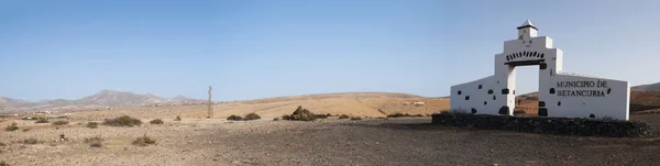 Fuerteventura, Ilhas Canárias, Espanha: montanhas e paisagem desértica com o sinal do município de Betancuria construído em forma de uma casa colonial espanhola — Fotografia de Stock