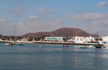 Fuerteventura, Kanarya Adaları, İspanya: volkan Bayuyo, doğrudan kuzeydoğu kasaba, Corralejo, adanın ana beldesi limanda kayıkları ile görülen yükselen ile Corralejo manzarası