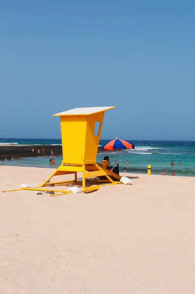 Fuerteventura, Kanárské ostrovy, Španělsko: žlutá strážní věž a panoramatický pohled z pláži Grandes Playas (The velké pláže), jeden z slavných pláží pro kitesurfing a windsurfing v severovýchodní pobřeží ostrova — Stock fotografie