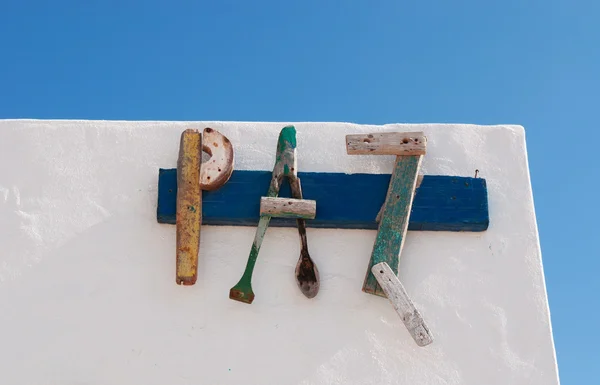 Fuerteventura, kanarische inseln, spanien: das wort peace, paz auf spanisch, zusammengesetzt aus hölzernen teilen alter boote auf einer weißen wand in der altstadt el cotillo, einem fischerdorf rund um einen kleinen hafen — Stockfoto