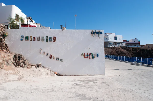 Fuerteventura, Kanarische Inseln, Spanien: die Worte Hoffnung, Illusion, Frieden und Heiterkeit, auf Spanisch esperanza, ilusion und alegria, zusammengesetzt aus Holzteilen alter Boote an einer weißen Wand in der Altstadt von el cotillo — Stockfoto