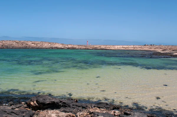 Fuerteventura, kanarische inseln, spanien: der strand der kleinen bucht caleta de la adana mit blick auf den leuchtturm el toston — Stockfoto