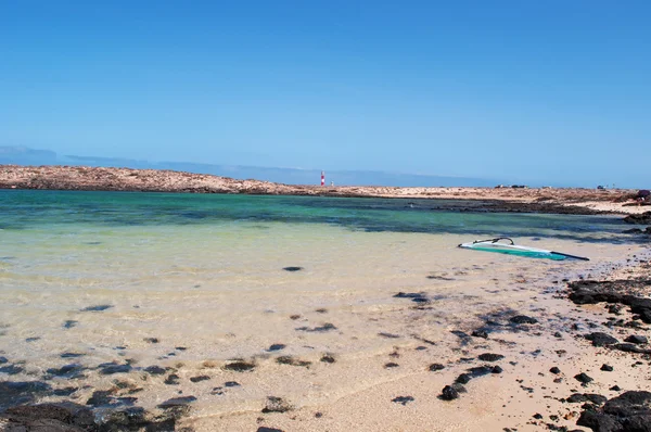 Fuerteventura, kanarische inseln, spanien: der strand der kleinen bucht caleta de la adana mit blick auf den leuchtturm el toston — Stockfoto