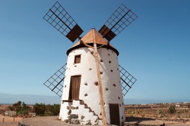 Fuerteventura, Canary Islands, Spain: desert landscape and countryside with the famous and traditional windmill in the village of El Roque, in the northwestern part of the island clipart