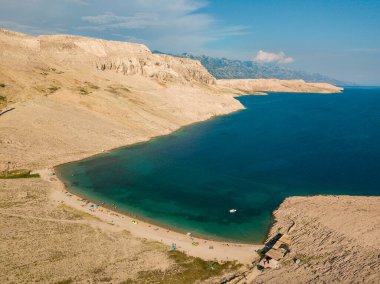 Hırvatistan 'ın Metajna kentindeki Pag Adası' ndaki Rucica plajının hava manzarası. Deniz yatağı ve plaj yukarıdan görünüyor, banyolar, rahatlama ve yaz tatilleri. Hırvat kıyılarının önyargıları ve uçurumları.