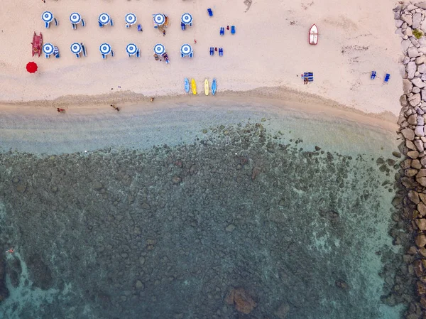 Aerial view of a beach and umbrellas. Tropea, Calabria, Italy. Parghelia. Overview of seabed seen from above, transparent water. Swimmers, bathers floating on the water. Lido La Grazia — Stock Image Aerial View Beach Umbrellas Tropea Calabria Italy Parghelia Overview Seabed Stock Image