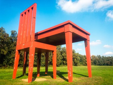 Monza Parkı 'ndaki Giancarlo Neri' nin yazarı. 10-17-2020. Sandalye ve masa, parkın yeşilliğiyle çevrili bir sanat kurulumu uyum içinde, çevresindeki doğayla bir bağlantı oluşturuyor.