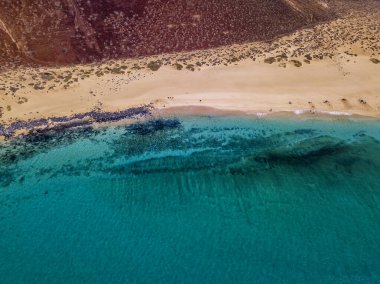 Aerial view of the jagged shores and beaches of La Graciosa island. Bathers on the beach of las Conchas. The main archipelago island Chinijo, a mile northwest of Lanzarote. Canary island. Spain. Ocean view and sand beach  clipart