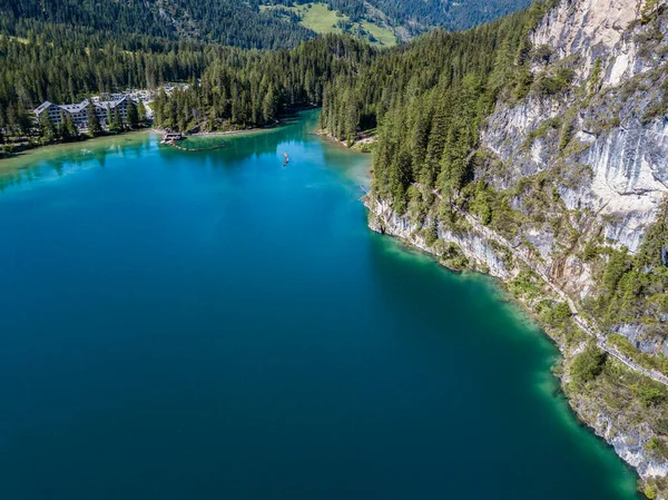 Aerial view of the Lake Braies, Pragser Wildsee is a lake in the Prags Dolomites in South Tyrol, Italy. People walking and trekking along the paths that run along the lake