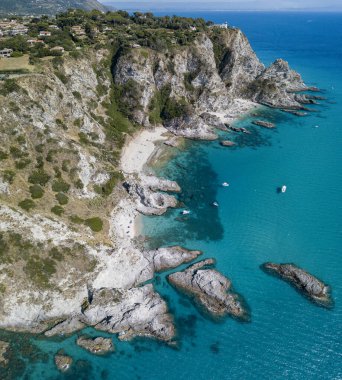 Capo Vaticano 'nun havadan görünüşü, Calabria, İtalya. Deniz feneri ve promontuar. Denize bakan kayalar. Praia I Focu plajı ve Ficara plajı. Tekneler, banyolar ve kristal berrak deniz. Costa degli Dei