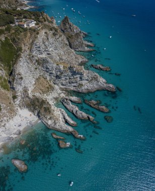 Capo Vaticano 'nun havadan görünüşü, Calabria, İtalya. Deniz feneri ve promontuar. Denize bakan kayalar. Praia I Focu plajı ve Ficara plajı. Tekneler, banyolar ve kristal berrak deniz. Costa degli Dei