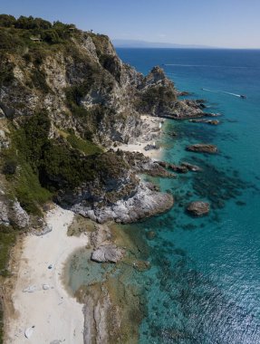 Capo Vaticano 'nun havadan görünüşü, Calabria, İtalya. Deniz feneri ve promontuar. Denize bakan kayalar. Praia I Focu plajı ve Ficara plajı. Tekneler, banyolar ve kristal berrak deniz. Costa degli Dei