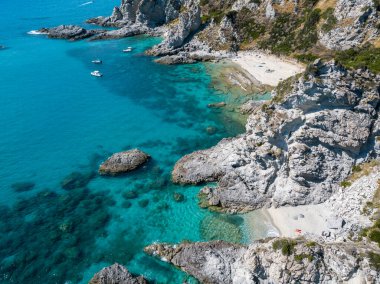 Şeffaf bir denizde yüzen demirli teknelerin havadan görüntüsü. Tüplü dalış ve yaz tatili. Capo Vaticano, Calabria, İtalya. Promontory 'de. Praia Odak Noktası ve Ficara Sahili.