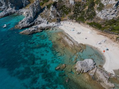 Şeffaf bir denizde yüzen demirli teknelerin havadan görüntüsü. Tüplü dalış ve yaz tatili. Capo Vaticano, Calabria, İtalya. Promontory 'de. Praia Odak Noktası ve Ficara Sahili.